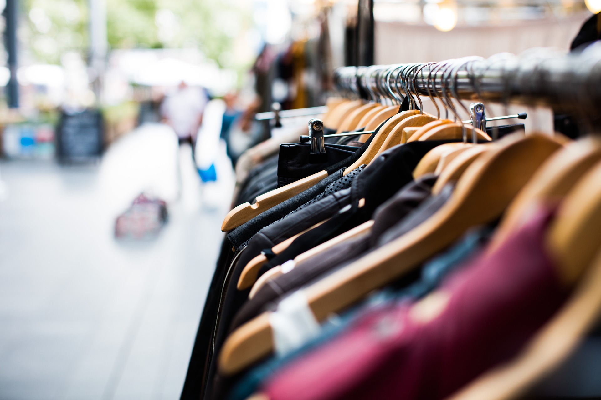A row of clothes on hangers within a shop
