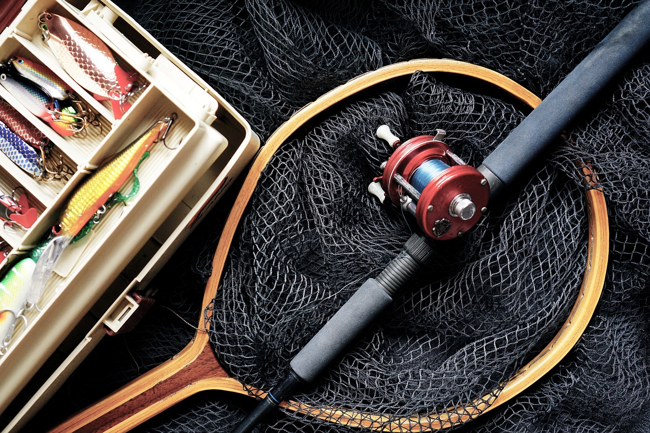 A fishing reel and a net lying next to a tackle box