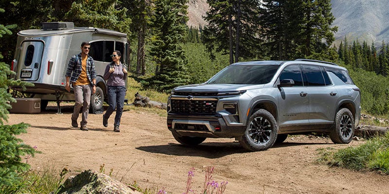 A couple camping outdoors with their 2026 Chevy Traverse